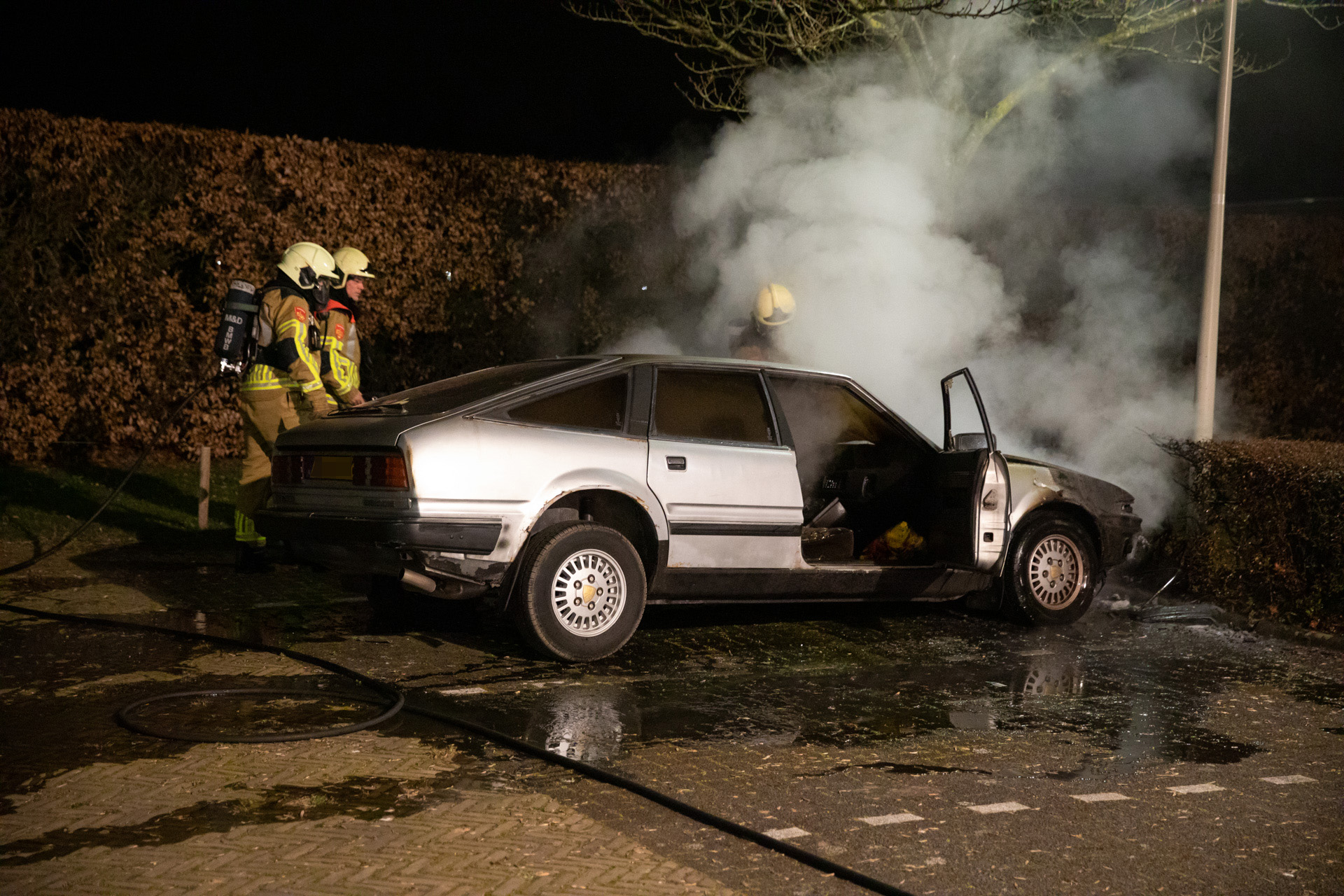 Oldtimer in brand op parkeerplaats in Wouw
